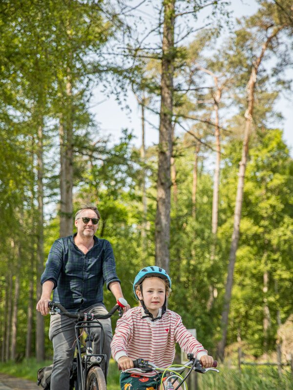 Papa en dochter op de fiets in het Drongengoedbos